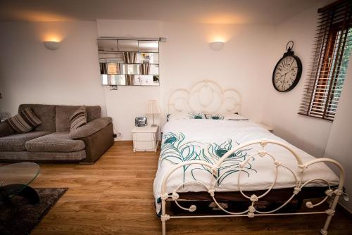 伍斯特Spring Meadow的一间卧室配有一张床、一张沙发和一个时钟