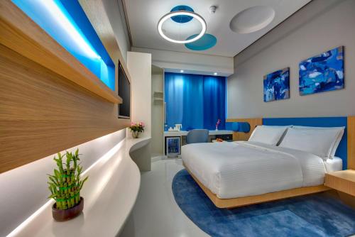 迪拜杜拜阿尔库利因布尔酒店的一间卧室配有大床和蓝色的灯光