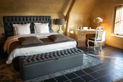 贝拉克尔Boutique Hotel De Brakelhoen的一间卧室配有一张床、一张桌子和一把椅子