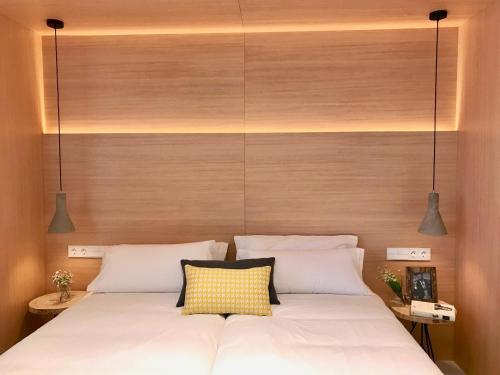 毕尔巴鄂Inside Bilbao Apartments的一间卧室,配有一张带两盏灯的床。