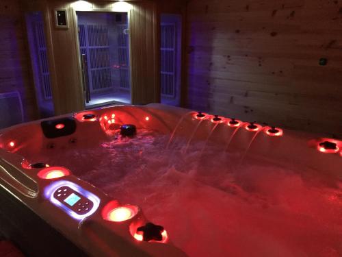 圣谢利多布拉克AUBRAC Spa的客房内的红色浴缸配有灯光