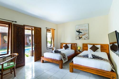普卢坎Arton Resort & Beach Club的一间卧室配有两张床和一张桌子及椅子