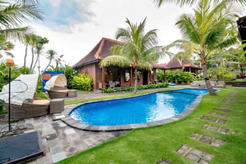 普卢坎Arton Resort & Beach Club的棕榈树屋前的游泳池