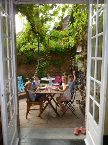 Mouvaux老雪松住宿加早餐旅馆的一群坐在庭院桌子上的孩子