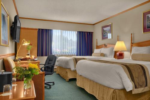 艾伯尼港好客酒店的酒店客房配有两张床和一张书桌