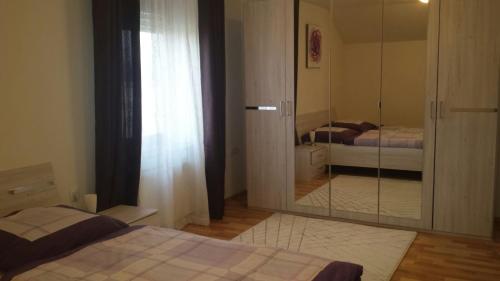 多姆扎莱Apartma Rodica的一间带镜子的卧室和两张床
