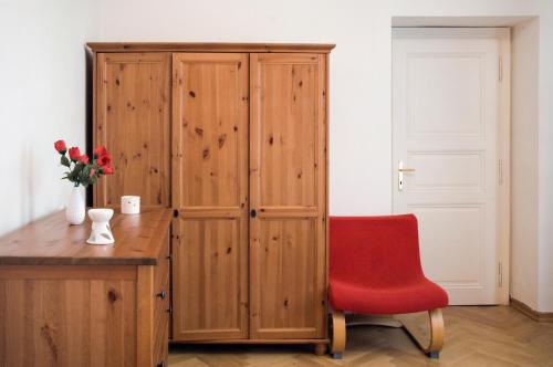 布拉格艾卡特罗安杰利酒店的一张红色椅子,坐在木柜旁