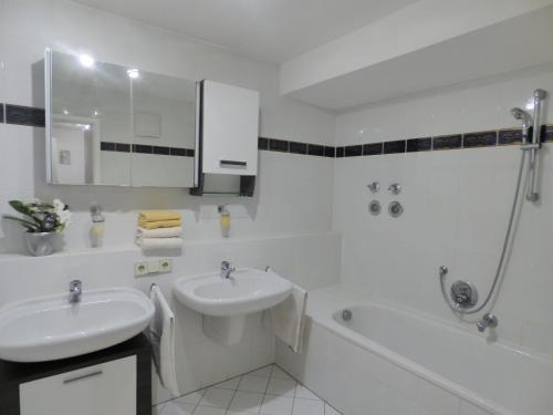 巴登-巴登Domino Apartment的白色的浴室设有水槽和浴缸。