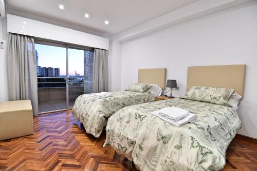 马拉加Apartamento Luxury Reding的一间卧室设有两张床和大窗户
