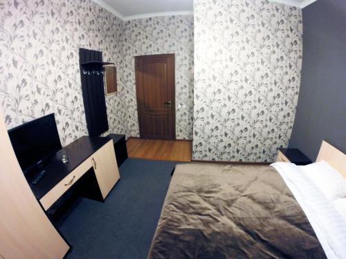 阿斯塔纳Mini-Hotel Pulsar的卧室配有床、书桌和门