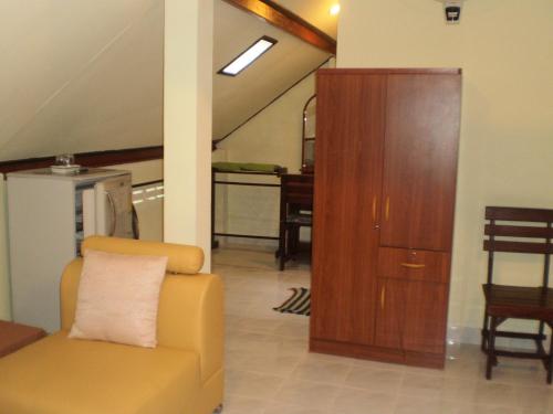 卡伦海滩普吉岛绿色家园旅馆的客厅配有黄色椅子和木柜