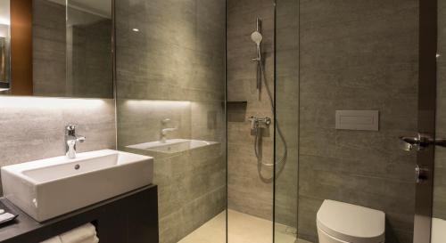 新加坡明古连30酒店的浴室配有盥洗盆、卫生间和淋浴。