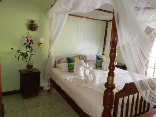 本托塔Mahi Villa的一间卧室配有一张天蓬床和天鹅
