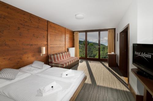 什平德莱鲁夫姆林亚当酒店的酒店客房配有床、沙发和电视。
