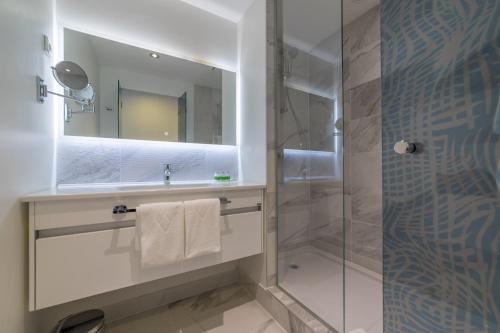 希贝尼克Amadria Park Family Hotel Jakov的带淋浴、盥洗盆和镜子的浴室