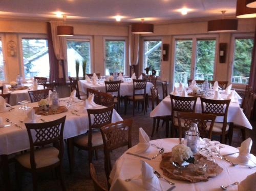 伊瑟隆Hotel Peiler Garni的一间设有白色桌椅和窗户的用餐室