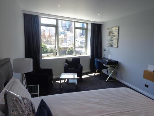 墨尔本码头西建筑私人一室公寓的配有一张床、一张书桌和一扇窗户的酒店客房