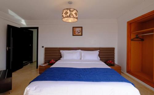 马拉喀什莫纳公寓式酒店的一间卧室配有一张带蓝色毯子的大床