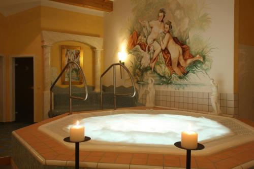 博登迈斯博尔霍夫维塔尔康体酒店的一个大浴缸,里面放着两个蜡烛