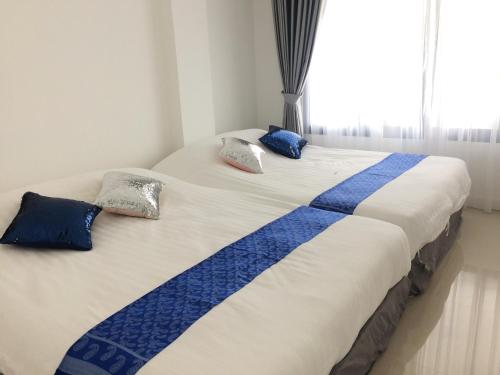 华欣@钱恩泳池别墅的一张带蓝色和白色毯子及枕头的床