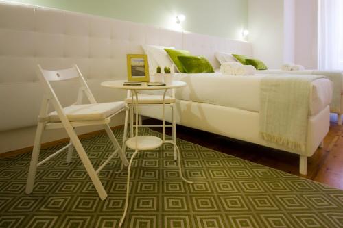 波尔图特瑞斯达迪住宿加早餐旅馆的卧室配有1张床、1张桌子和1把椅子