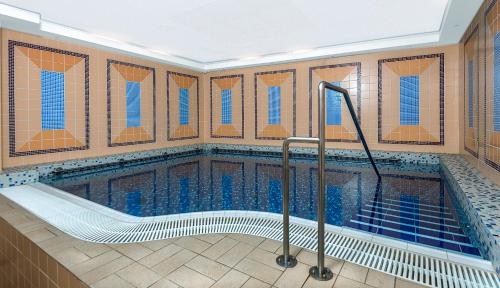 玛丽亚温泉大洲酒店的蓝色瓷砖建筑中的游泳池