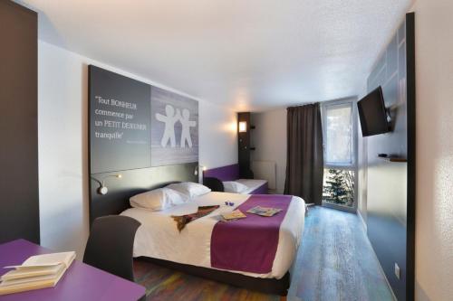 布里昂松Suite Home Briancon Serre Chevalier的酒店客房设有一张大床和一张书桌。