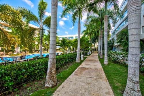 卡塔赫纳Estelar Playa Manzanillo - All inclusive的穿过棕榈树的步道,毗邻游泳池