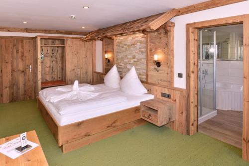 菲尔伯格温德酒店的带淋浴的客房内的一间卧室,配有一张床