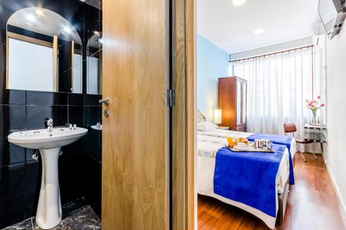 波尔图波尔图圣克拉拉旅馆的一间带水槽的浴室和一张位于客房内的床