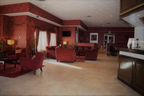 丹顿Texas Inn & Suites的大型客厅设有红色的墙壁和家具