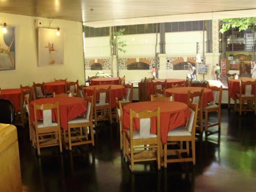 蒙得维的亚克利酒店的餐厅配有桌椅和红色桌布