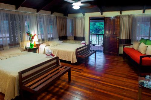 萨拉皮基Selva Verde Lodge的一间带两张床和一张沙发的卧室