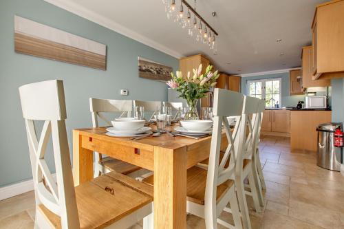 海滨韦尔斯港Tolly House的厨房以及带木桌和椅子的用餐室。