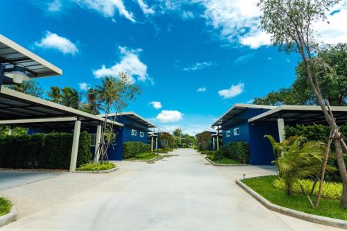 北碧P之家汽车旅馆的蓝天两座蓝色建筑之间的道路