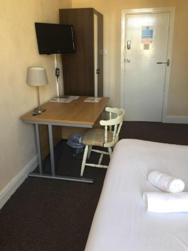 克莱克西顿Gateway Lodge的一张桌子,位于酒店的房间,配有一张床和一张桌子及电脑