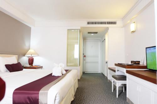 清迈Star Hotel Chiang Mai - SHA Extra Pus的配有一张床和一张书桌的酒店客房