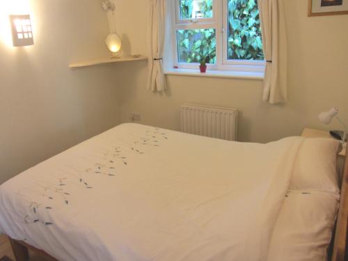 伊斯特雷格斯特普度假屋的卧室内的一张白色床,设有窗户