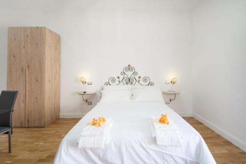 那不勒斯Eugenia e Donato的卧室配有白色床,上面有橙色的鲜花