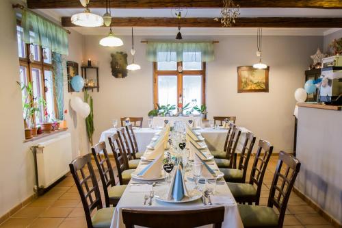阿德尔什帕赫Penzion Adršpach u Báry的一间带长桌和椅子的用餐室