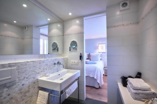 德哈恩及时行乐浪漫庄园酒店的白色的浴室设有水槽和一张床