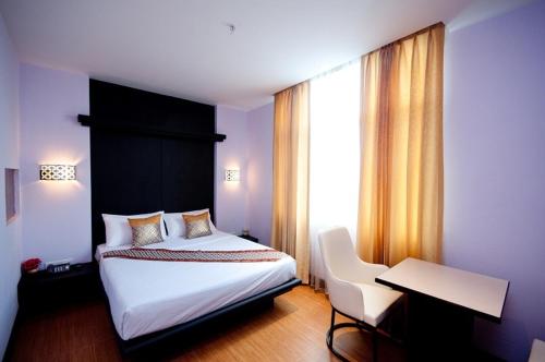 曼谷暹罗天堂娱乐综合酒店的一间卧室配有一张床、一张书桌和一个窗户。