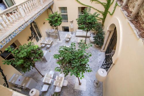 塞维利亚珀蒂帕拉斯圣克鲁斯酒店的享有庭院的顶部景致,庭院内拥有桌子和树木