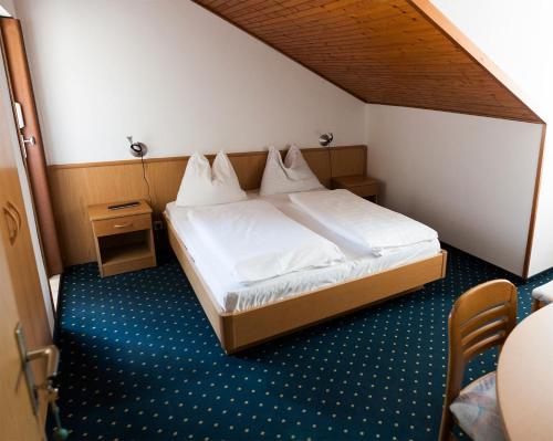 奥拉Gasthaus Abram的配有一张床和一把椅子的酒店客房