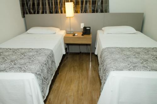 贝洛奥里藏特营帕埃克斯颇敏纳斯公寓的客房设有两张床、一张书桌和电话