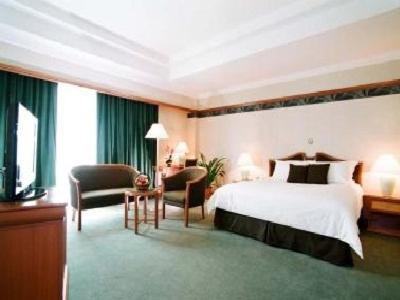 米里嘉逸豪庭酒店的大型酒店客房,配有床和椅子