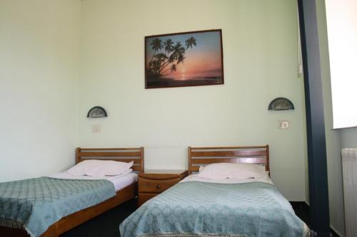 斯拉蒂纳帕拉迪斯酒店的卧室配有两张床,墙上挂着一幅画