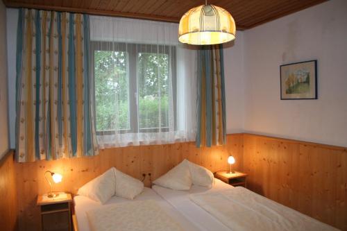 蒂罗尔-基希贝格霍尔罗斯酒店的一间卧室配有一张床、一个窗口和两盏灯。