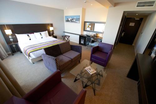 滨海绍森德绍森德假日酒店的酒店客房配有一张床、一张沙发和椅子。