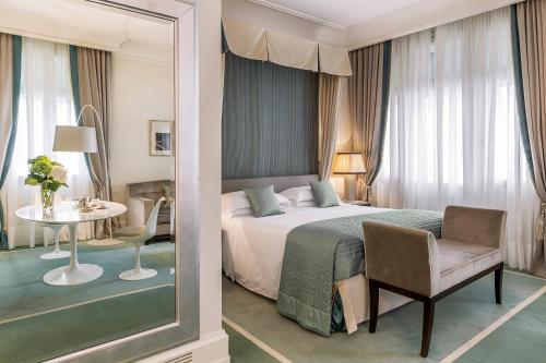 的里雅斯特里雅斯特萨瓦尔星际酒店的卧室配有1张床、1张桌子和1把椅子